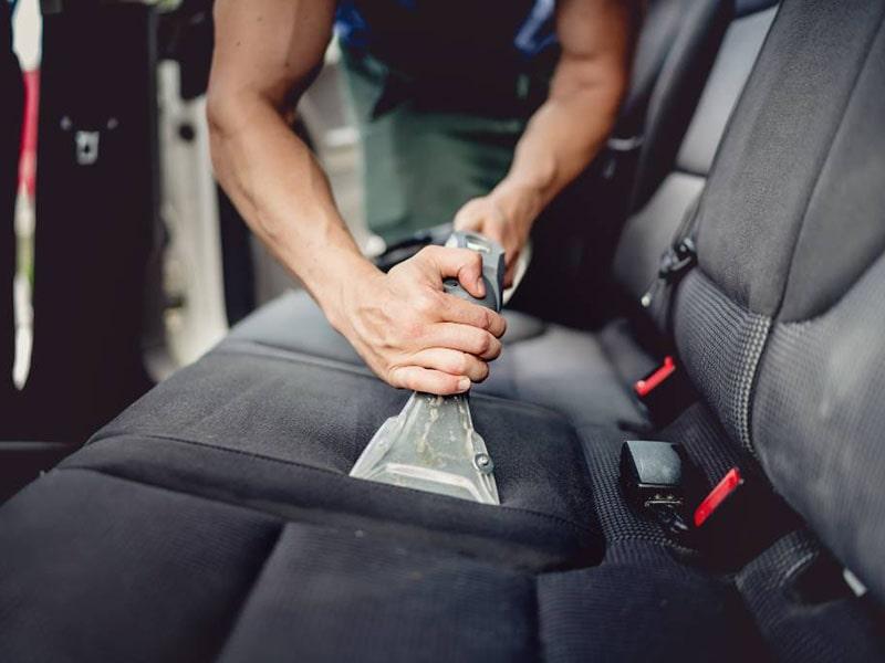 An extraction tool cleaning fabric on a vehicle rear seat