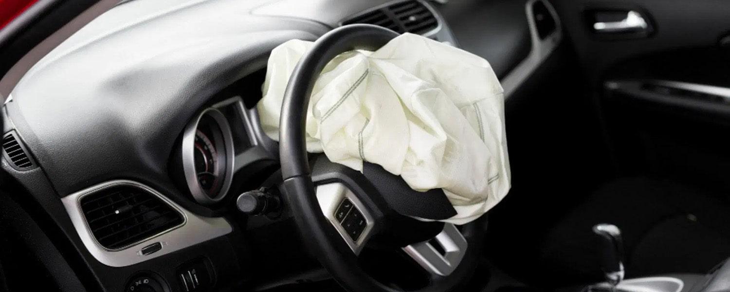Deployed driver airbag extending from the steering wheel