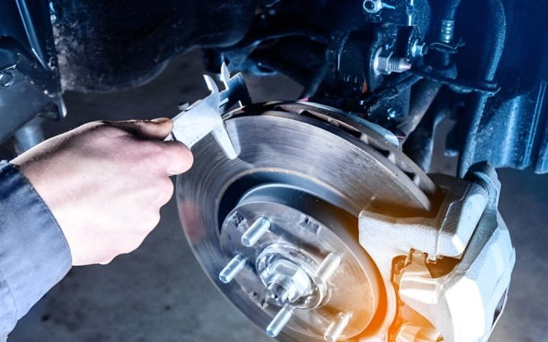 Brake disc being checked with a measuring tool