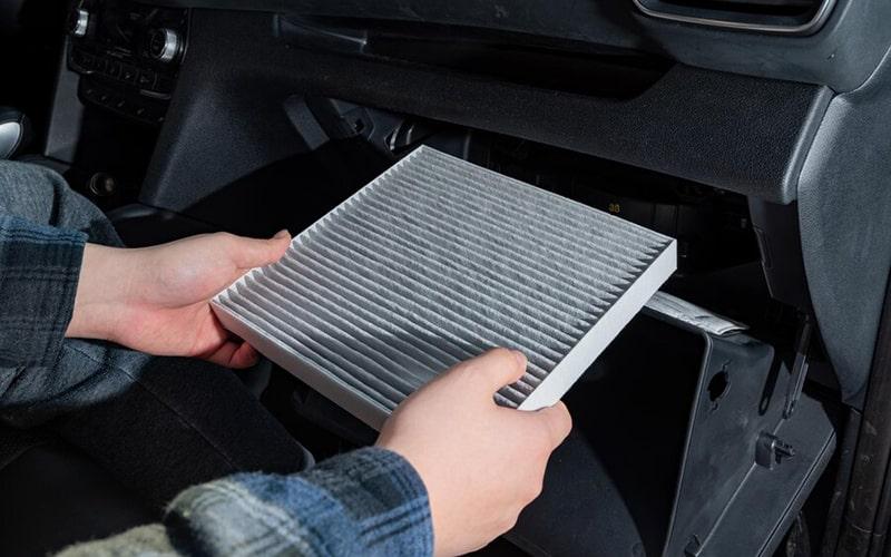 Cabin air filter held beside the open glovebox access area