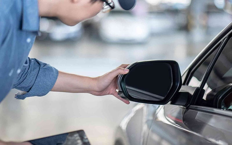 Technician checking the exterior mirror on a car