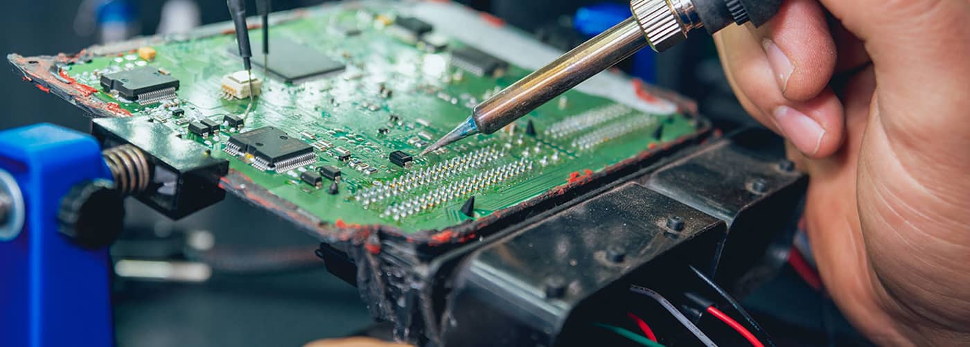 Technician working on an engine control unit circuit board