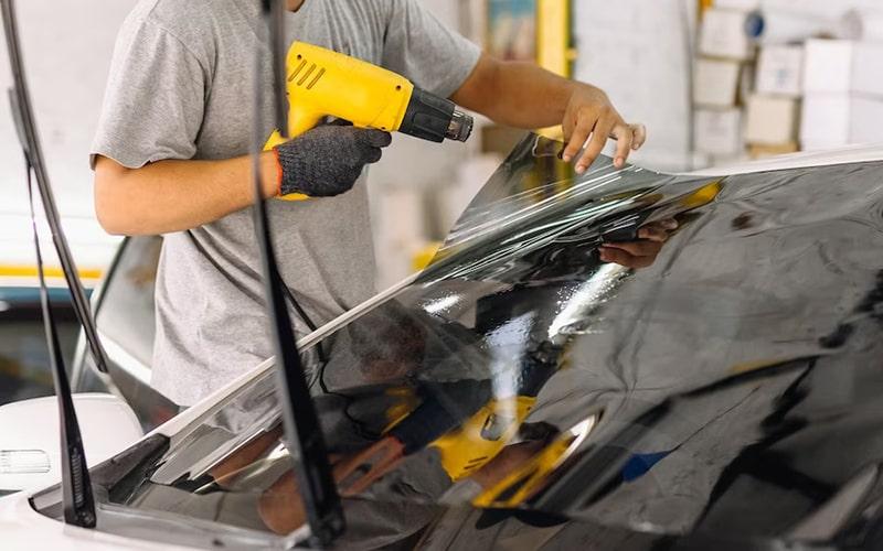 Installer shaping window film on curved rear glass