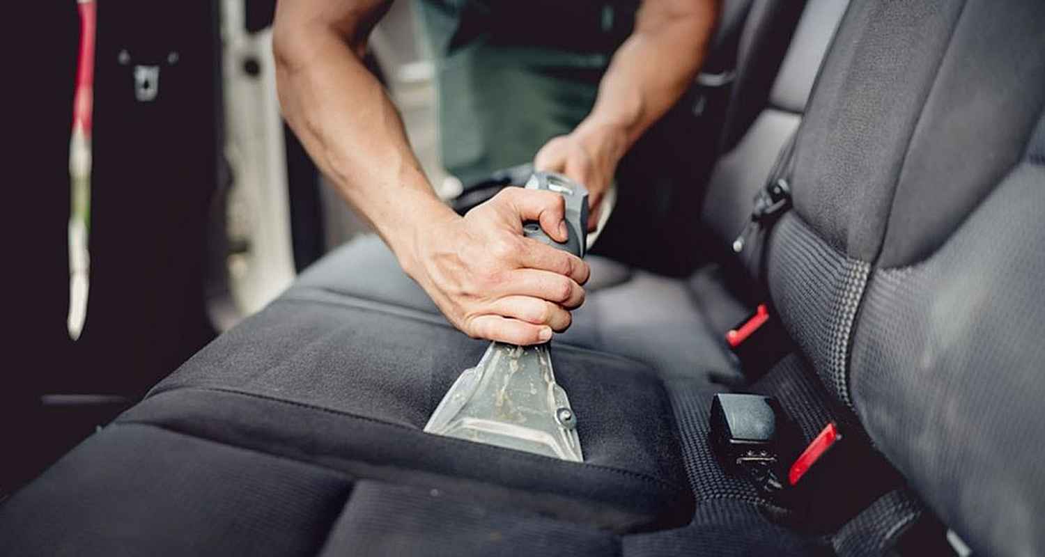 Fabric rear seat being cleaned with an upholstery extraction tool
