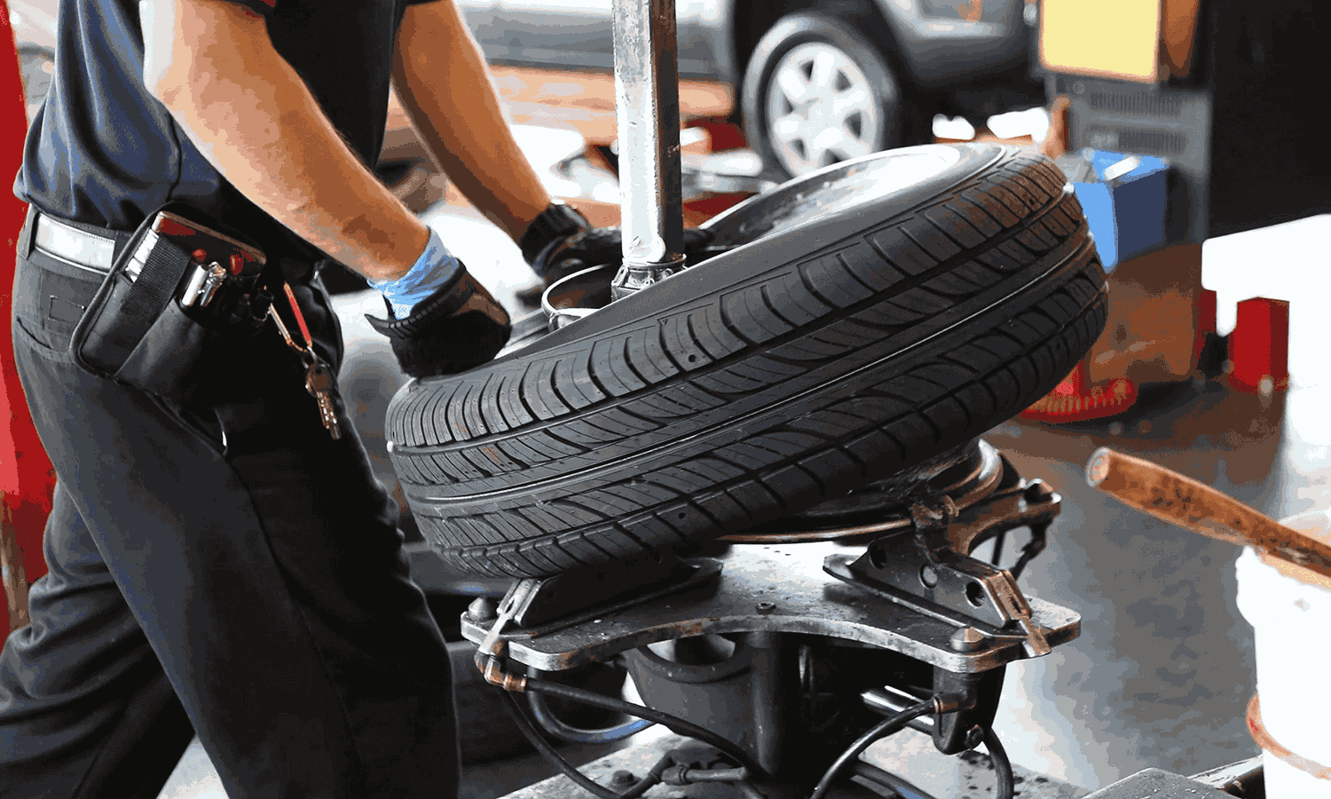 Technician positioning a tire on a tire-changing machine