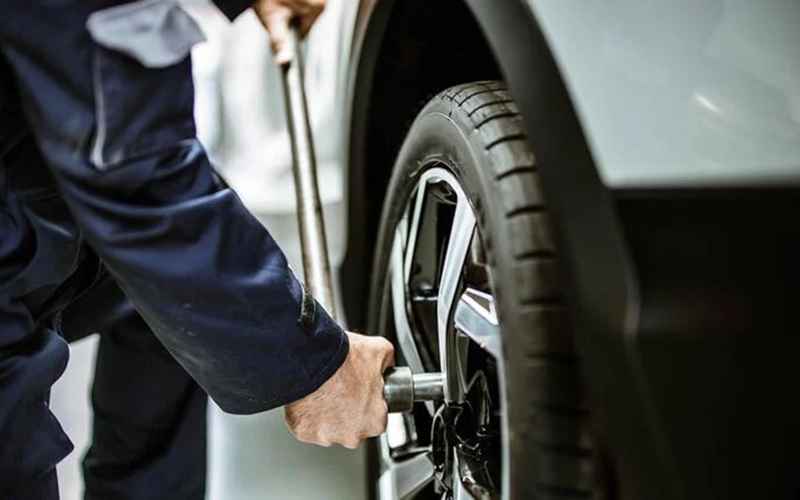 Technician working at a fitted wheel on a car