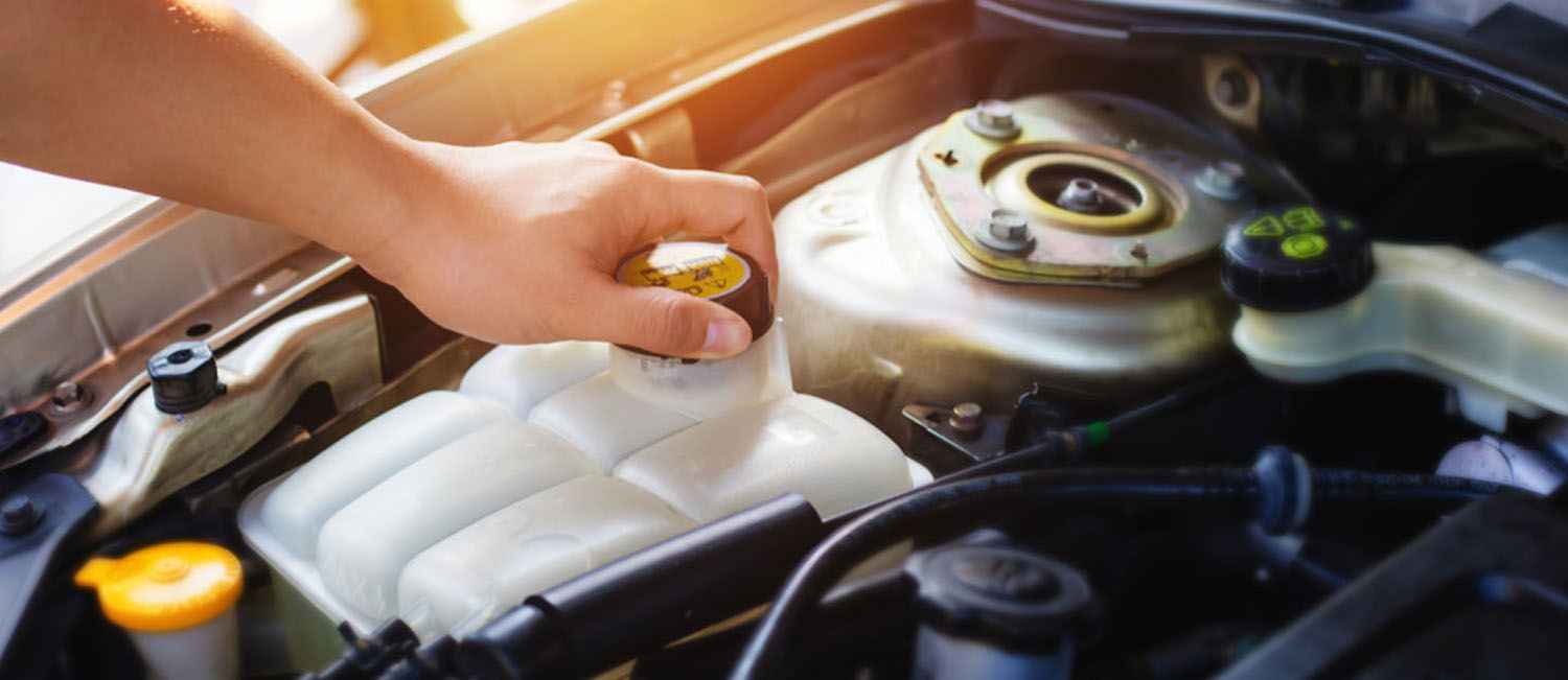 A coolant expansion reservoir and its pressure cap in an engine bay