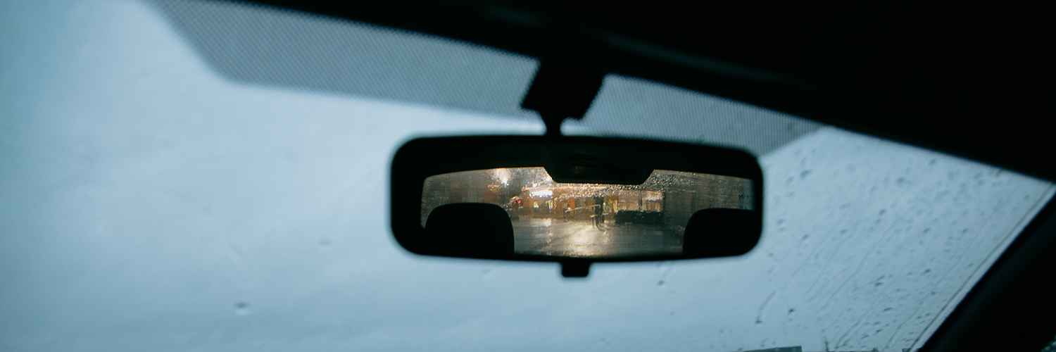 Interior rear view mirror seen through a wet windshield