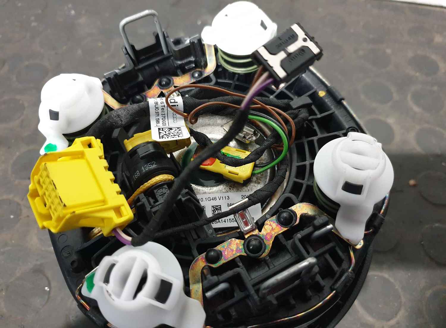 Rear of an airbag assembly showing its connectors and identification labels