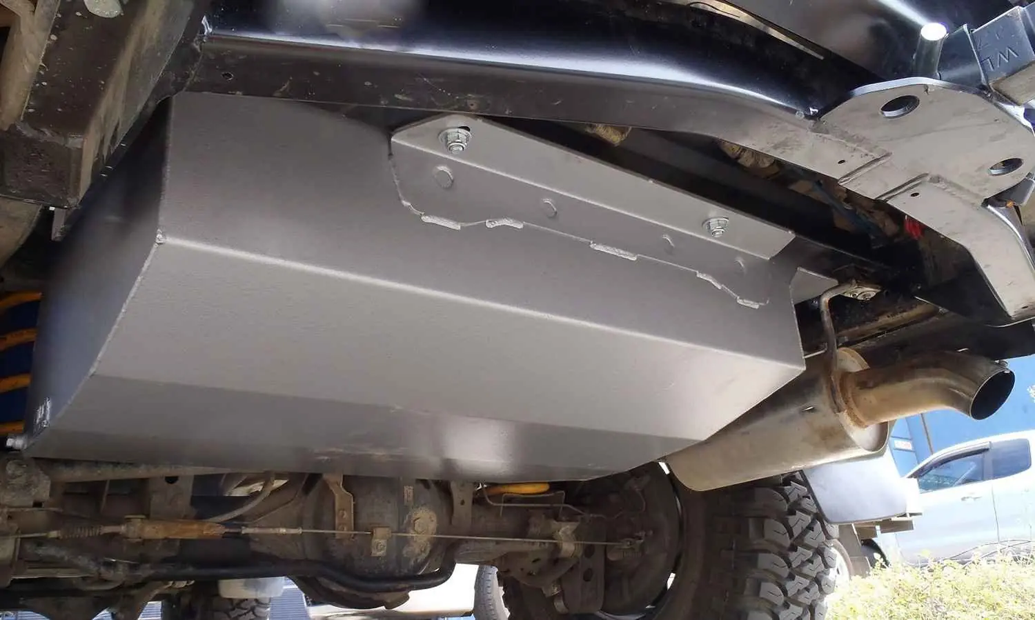 Fuel tank mounted beneath a vehicle raised for underbody access