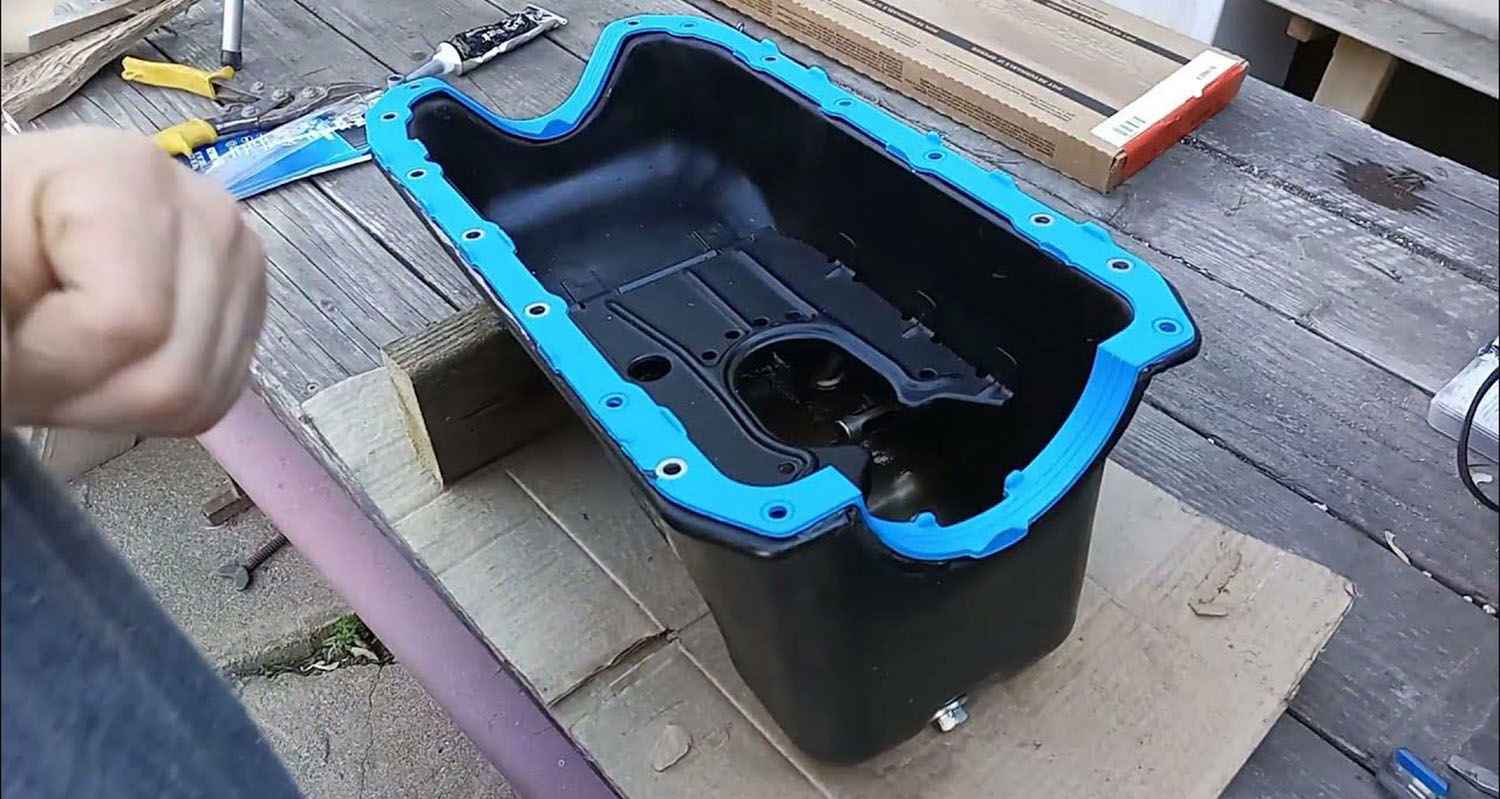 Removed oil pan with a replacement gasket positioned on its flange