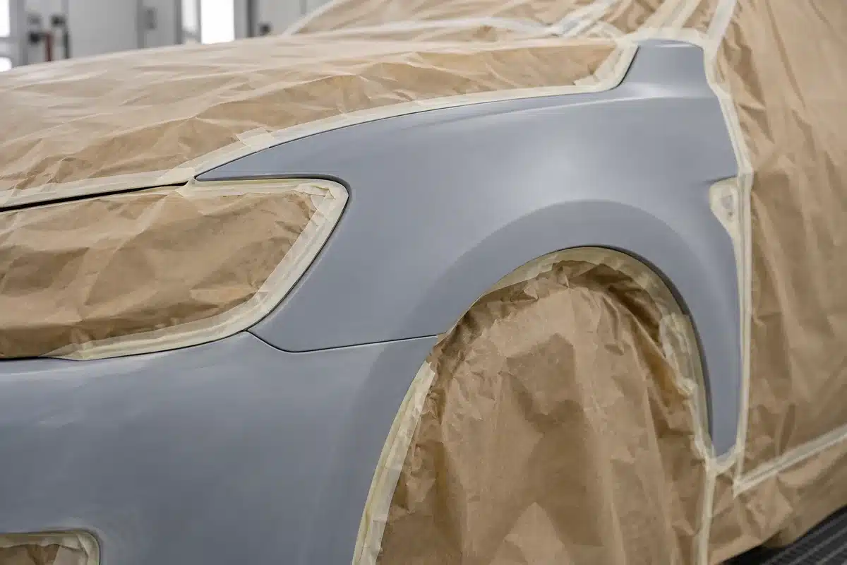 A primed car panel with the neighbouring surfaces masked