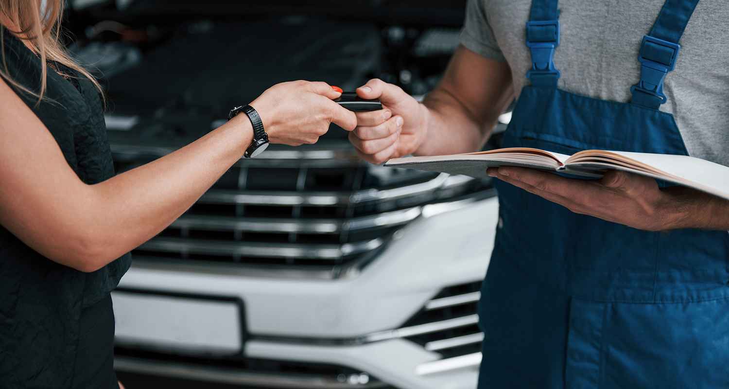 Customer discussing vehicle paperwork with a technician