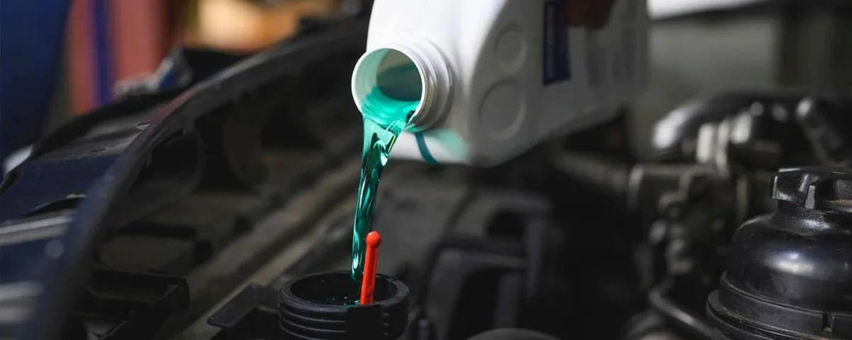 Coolant being poured into an engine expansion reservoir