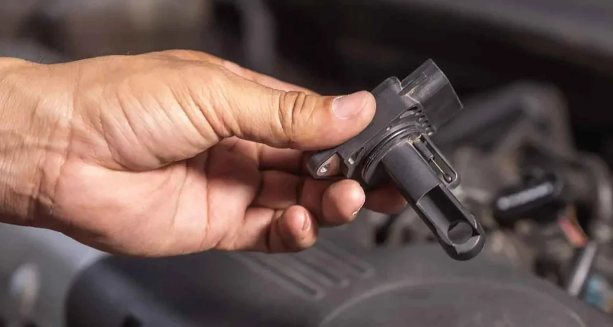 Mass airflow sensor held beside an engine bay