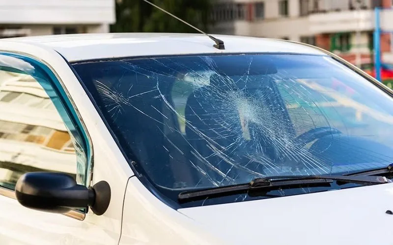 Extensive impact cracks across a front windscreen
