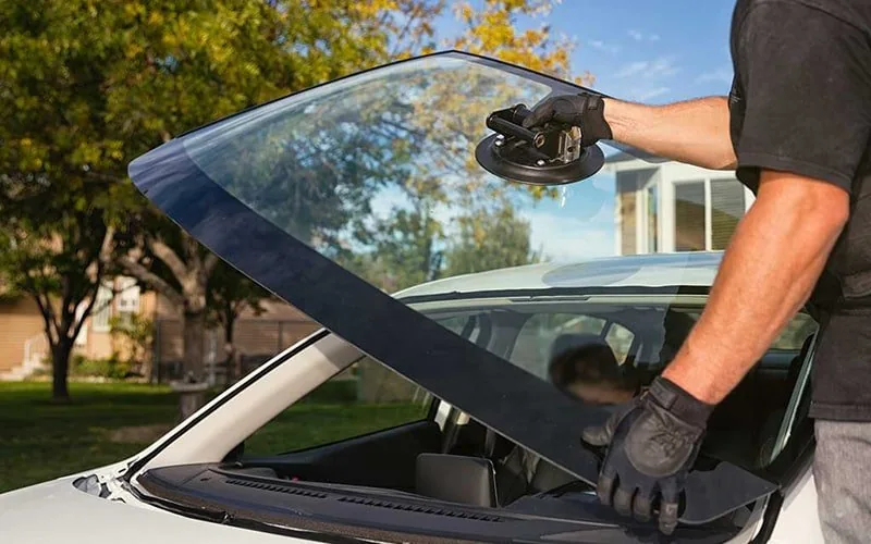 Replacement windscreen positioned with suction handles